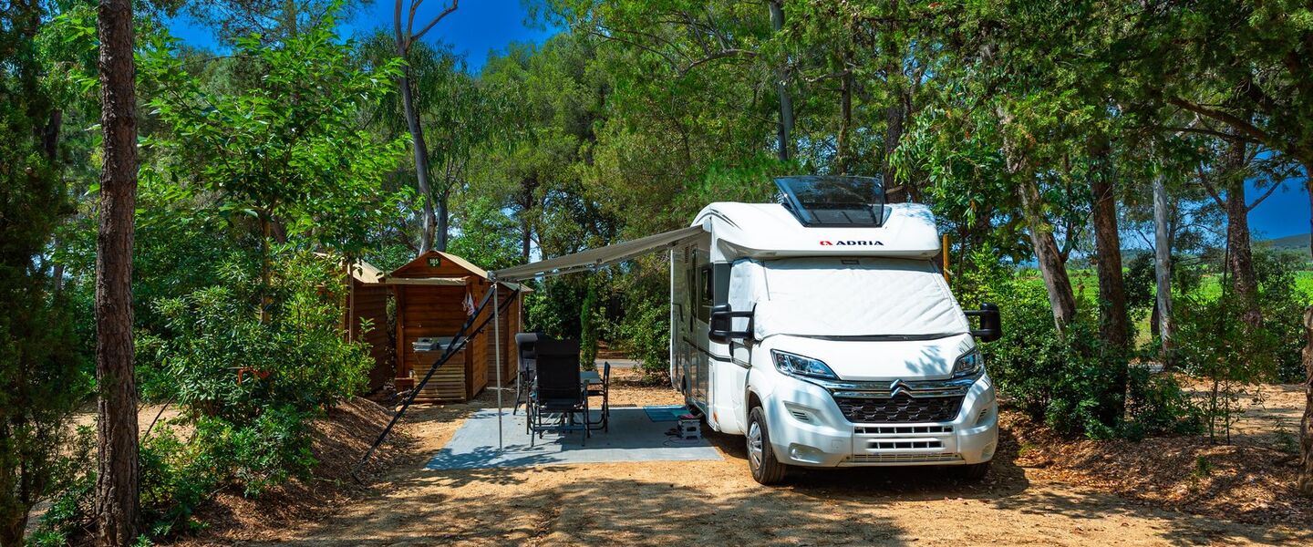 Caravan pitch with private sanitary facilities in tree-filled campsite